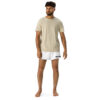 A curly-haired, bearded man stands barefoot on a white backdrop, wearing a beige t-shirt and stylish BAAS Athletic Shorts with BAAS printed on the leg. A curly-haired, bearded man stands barefoot on a white backdrop, wearing a beige t-shirt and stylish BAAS Athletic Shorts with BAAS printed on the leg.