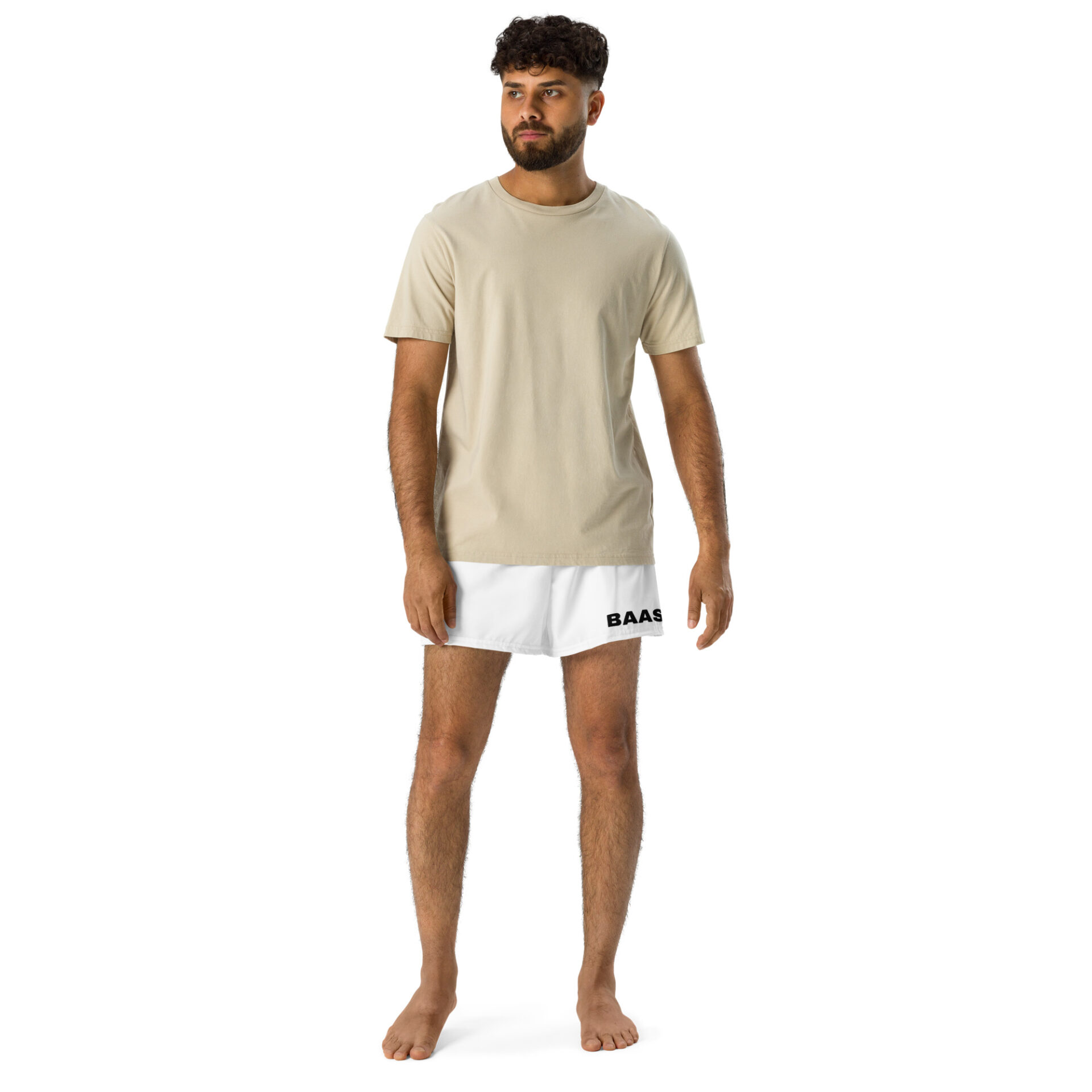 A curly-haired, bearded man stands barefoot on a white backdrop, wearing a beige t-shirt and stylish BAAS Athletic Shorts with BAAS printed on the leg. A curly-haired, bearded man stands barefoot on a white backdrop, wearing a beige t-shirt and stylish BAAS Athletic Shorts with BAAS printed on the leg.