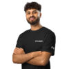 A bearded man with curly hair smiles with arms crossed, wearing an Under ArmourⓇ athletic t-shirt CHAMP against a plain white background. A bearded man with curly hair smiles with arms crossed, wearing an Under ArmourⓇ athletic t-shirt CHAMP against a plain white background.