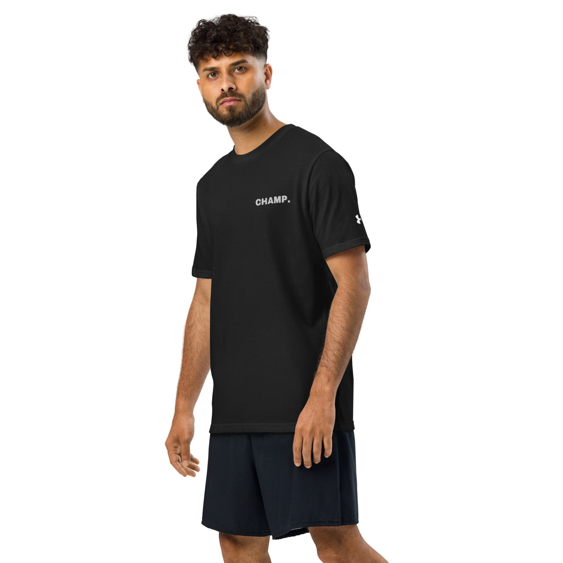 A man with curly hair and a beard wears a black Under ArmourⓇ athletic t-shirt CHAMP and black shorts, standing against a plain white background. A man with curly hair and a beard wears a black Under ArmourⓇ athletic t-shirt CHAMP and black shorts, standing against a plain white background.