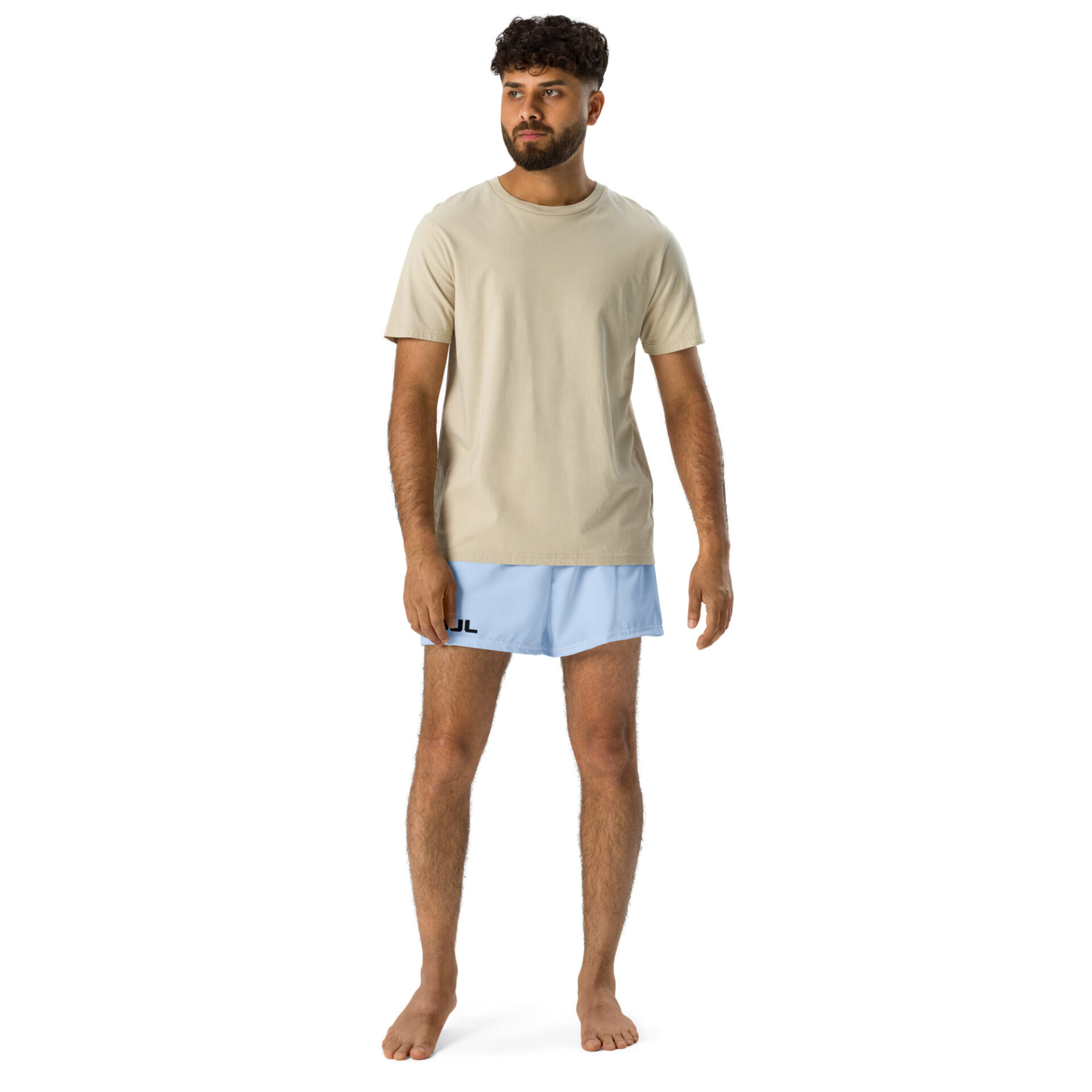 A man with curly hair and a beard stands barefoot against a white background, wearing a beige t-shirt and MJL Athletic Shorts in light blue with the MJL logo on the left leg. A man with curly hair and a beard stands barefoot against a white background, wearing a beige t-shirt and MJL Athletic Shorts in light blue with the MJL logo on the left leg.