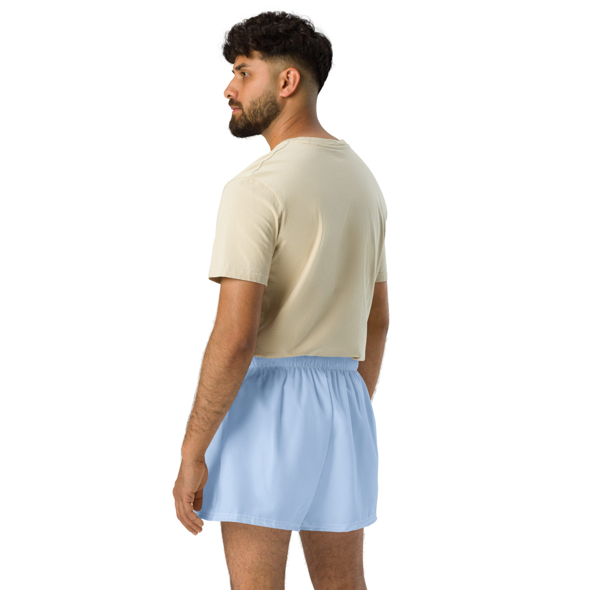 A man with short dark hair and a beard, wearing a beige T-shirt and light blue MJL Athletic Shorts, stands facing away against a plain white background. A man with short dark hair and a beard, wearing a beige T-shirt and light blue MJL Athletic Shorts, stands facing away against a plain white background.